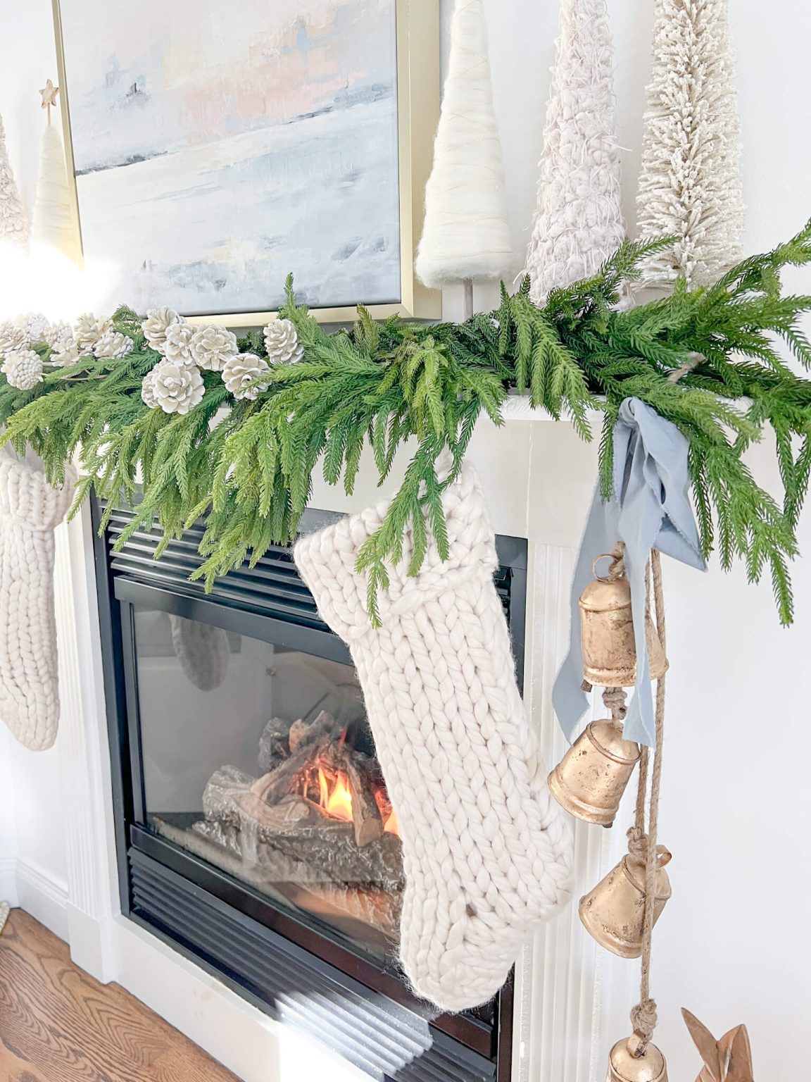 A styled mantel with fresh garland and brass candlesticks
